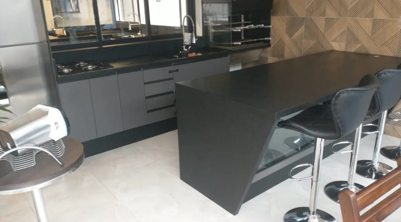 Área gourmet com bancada preta e acabamento sob medida